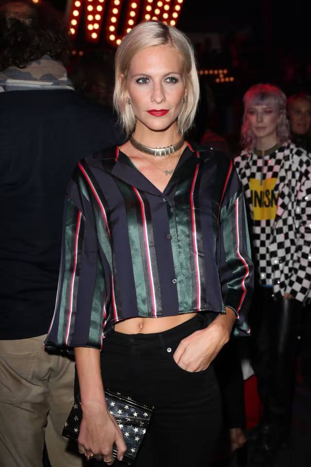 Poppy Delevinge Holding a Black Evening Clutch